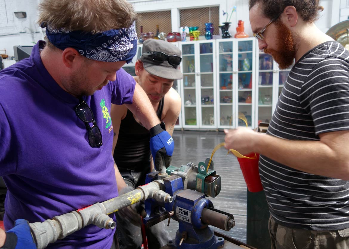 alt="Resident glassblower, Kyle Herr, and technicians, Drake Fuller and Zachary LeBlanc, replace the solenoid valve"