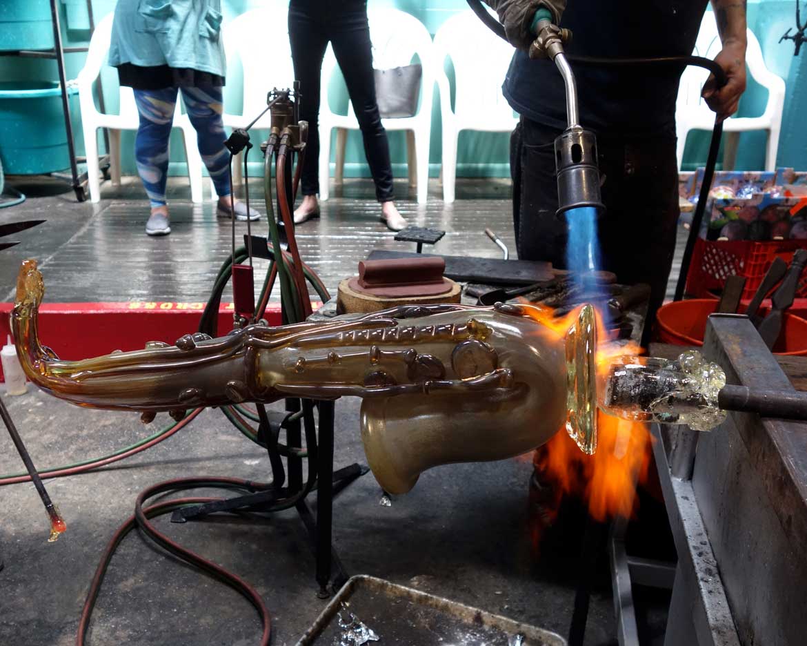 alt="Master glassblower Robert Stern torches the punty"